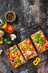 Homemade baking Detroit-Style pizza. Large rectangular Pepperoni pizza with mushrooms, salami and cheese on a stone tabletop. Top view flat lay background. Copy space.