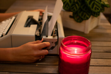 Caucasian teen hands changing the paper on a retro typewriter.