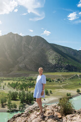 Fototapeta na wymiar Woman in blue dress on the confluence of two rivers Katun and Chuya in Altai mountains, beauty summer day