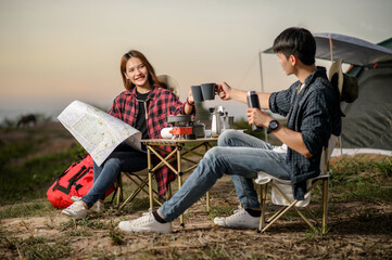 Fototapeta na wymiar Young couple relax with coffee at nature park during camping