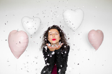 The emotion of success. Happy sexy brunette girl enjoying celebrating with confetti and heart...