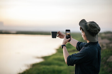 Young man use smartphone take a photo on camping trip