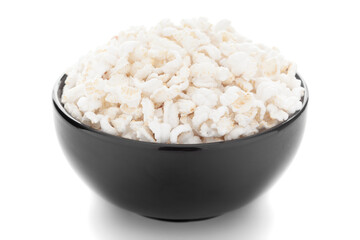 Close-up of organic  puffed / roasted rice (kheel or murmura)  in a black ceramic bowl over white background.