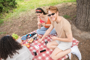 Top view of friends playing cards at picnic