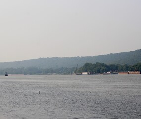 The barge and boats on the flowing river.