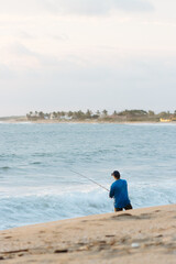 Senior latino man fishing at the beach morning copy space