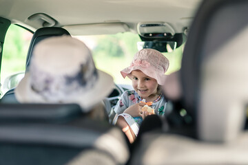 Little girl is having picnic in the car