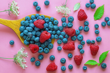 Summer wild berries: raspberries and blueberries .  Flat lay, pink paper background