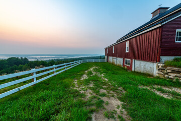 red barn in the morning with sunrise and fog
