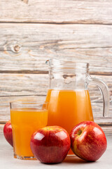 Apple juice and red apples on the table.