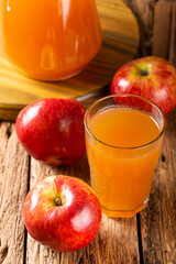 Apple juice and red apples on the table.