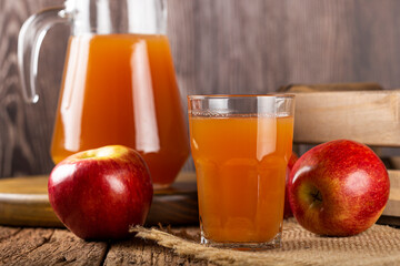 Apple juice and red apples on the table.