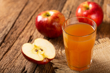 Apple juice and red apples on the table.
