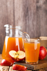 Apple juice and red apples on the table.