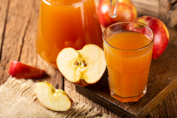 Apple juice and red apples on the table.