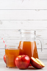 Apple juice and red apples on the table.
