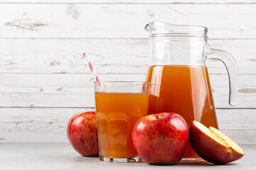 Apple juice and red apples on the table.