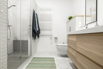 Modern minimalist bathroom interior design with white tiles, two white sinks and natural wood furniture