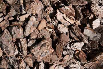 The texture of crushed tree bark on a close-up background. Crushed brown tree bark for...