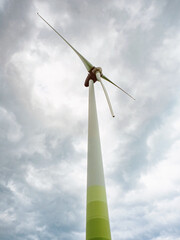 Wind turbines against cloudy sky in an open field