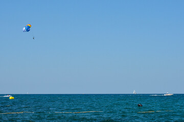 A parascender, or parasailer, and a speed boat off the Adriatic Sea coastline in July north of Novigrad, Istria, Croatia

