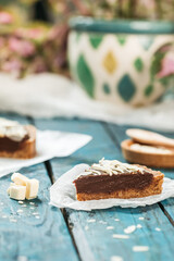 almond chocolate tart served on rustic blue wooden background 