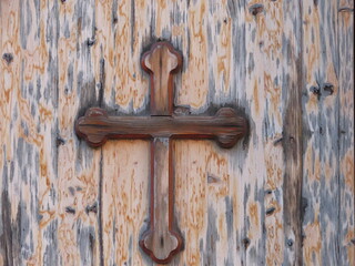 Wooden door with a cross - a symbol of the Christian religion in the Angel Gabriel Church in Haifa Atiqa, Israel, close-up.