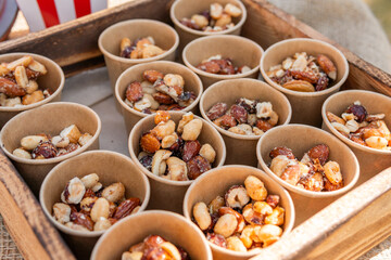 A lot of cups filled with different tasty caramelized nuts