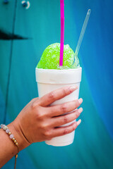 Woman's hand holding a colorful shave ice