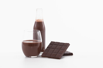 Bottle and glass of chocolate milkshake with chocolate bars: Selective focus. Chocolate concept