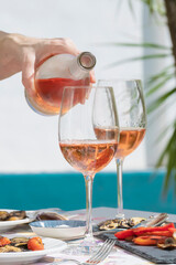 a hand of woman pouring delicious rose wine