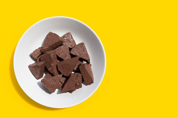 Chicken blood tofu in white bowl on yellow background