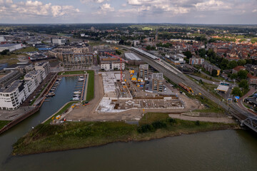 Construction site Kade Zuid part of the new Noorderhaven neighbourhood at river IJssel. Aerial industrial view of building plot. Housing and urban management.