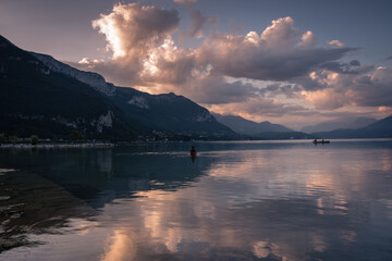 Natural landscape of Lake Annecy with colorful clouds at sunrise and Alps mountains in the background, Annecy, France