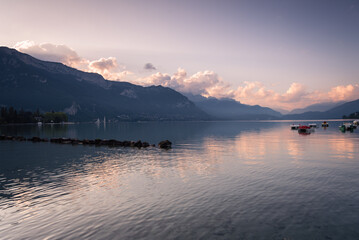 Fototapeta na wymiar Natural landscape of Lake Annecy with colorful clouds at sunrise and Alps mountains in the background, Annecy, France