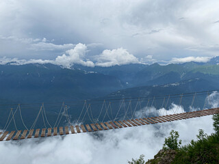 Rope bridge in the mountains at a height in the clouds