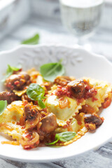 Ravioli with mushrooms and fresh basil. Bright wooden background. Close up. 