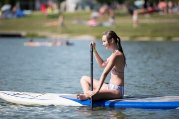 Young attractive woman on stand up paddle board, SUP(padleboarding)