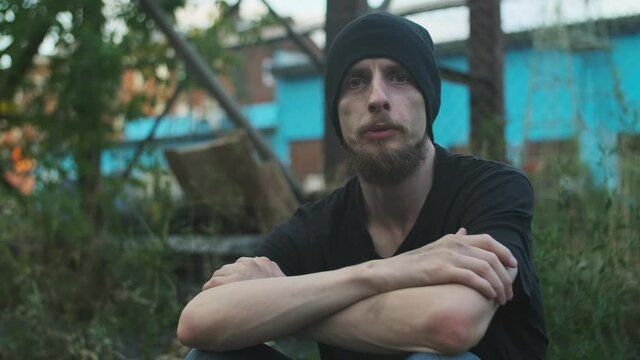 Homeless man sitting on the street on the cardboard box, telling his story. broken down person, gotten into poverty, misery, been laid off, fired, sacked. social problems, unemployment concept