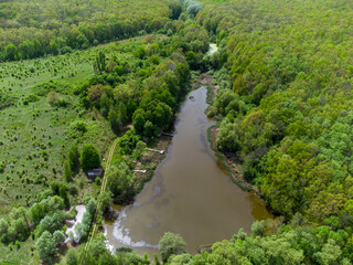 Fototapeta na wymiar Aerial sunny view on green summer small lake fishing spot. Greenery and wild lake drying and swamping