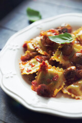 Ravioli with mushrooms and fresh basil. Dark wooden background. Close up