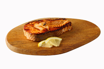 Piece of fried salmon with lemon on a wooden tray. Isolated on white. - 450167715