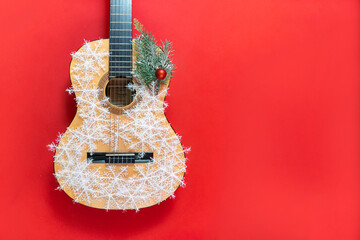 Christmas guitar on a red background in snowflakes. An invitation to a New Year's musical concert....