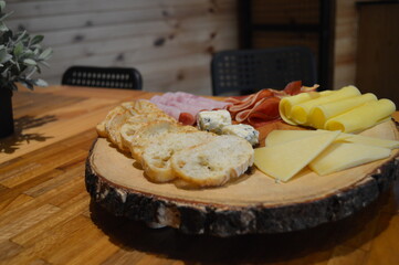 Tabla de quesos , queso azul, queso edam, queso de cabra, panes , tocino ahumado, jamonada