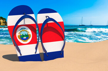 Flip flops with Costa Rican flag on the beach. Costa Rica resorts, vacation, tours, travel packages concept. 3D rendering