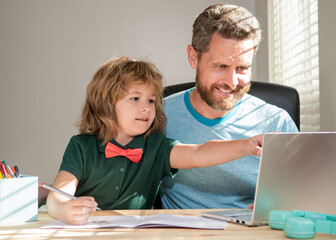Fototapeta na wymiar smiling father and son use communication technology at home. family blog. boy do homework