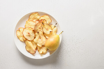 Fruits pear chips on a white background. Vegan dessert sugar free. View from above. Copy space.