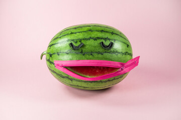 Watermelon with fake eyelashes and zipper mouth. On trendy soft pink background. Funny minimal makeup concept. With copy space.