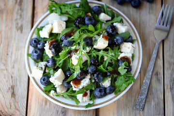 Healthy tasty salad with arugula, blue cheese and blueberries. Keto salad. Summer health food.
