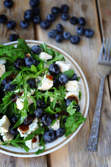 Healthy tasty salad with arugula, blue cheese and blueberries. Keto salad. Summer health food.